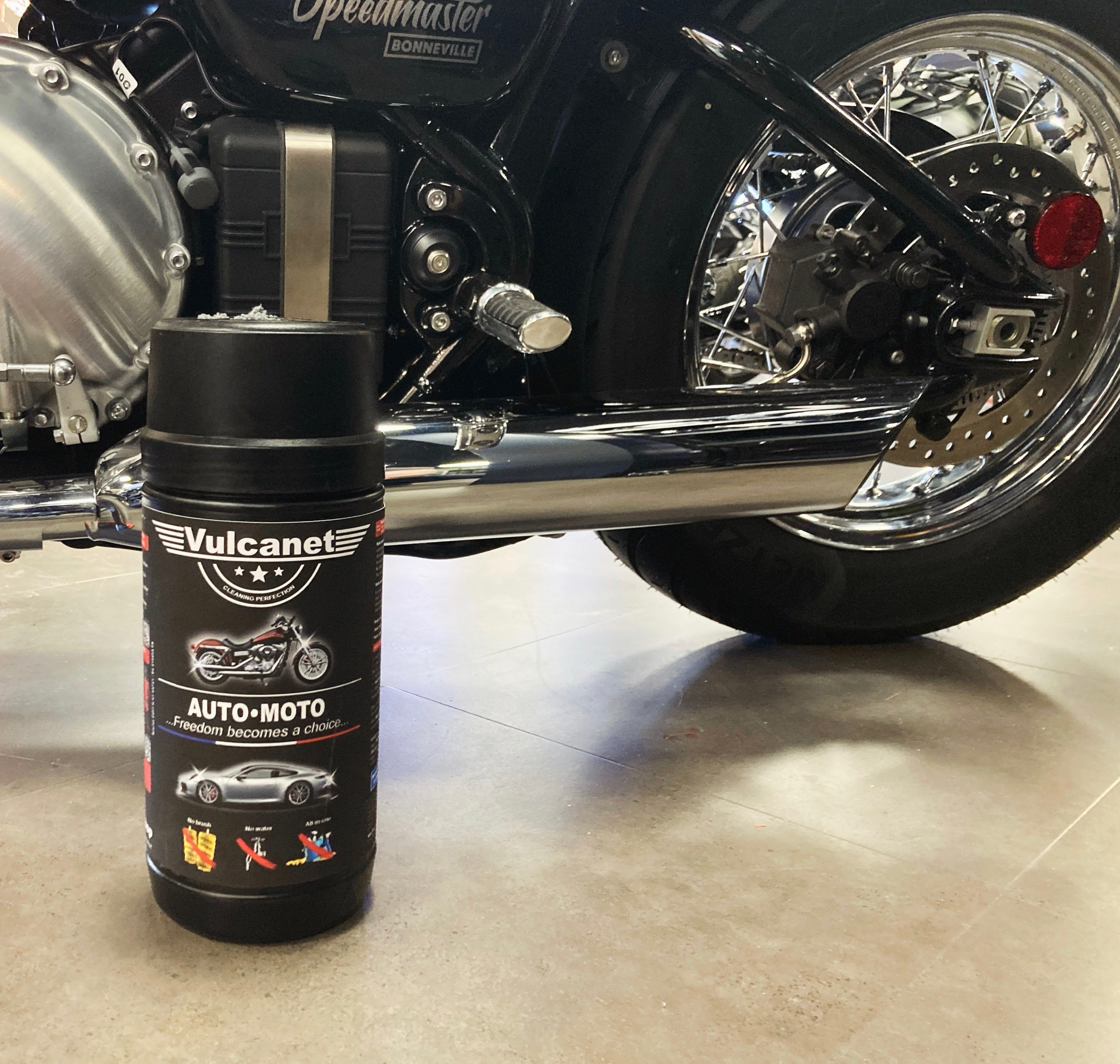 a canister of Vulcanet motorcycle cleaning wipes next to a triumph motorcycle